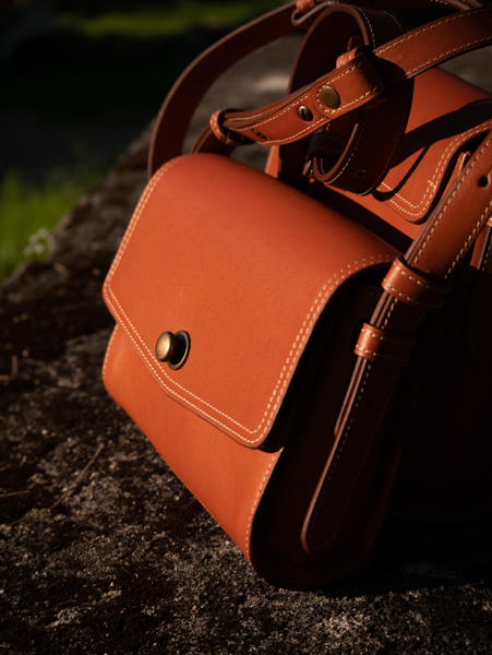 Sac à main ICONIK en cuir camel taille s présenté à la lumière naturelle