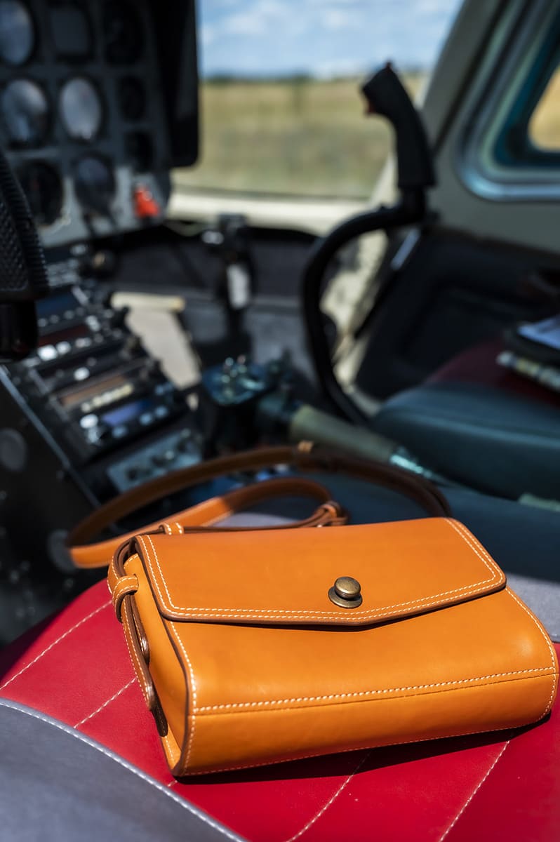 sac à main ICONIK taille S présenté sur un siège d'hélicoptère
