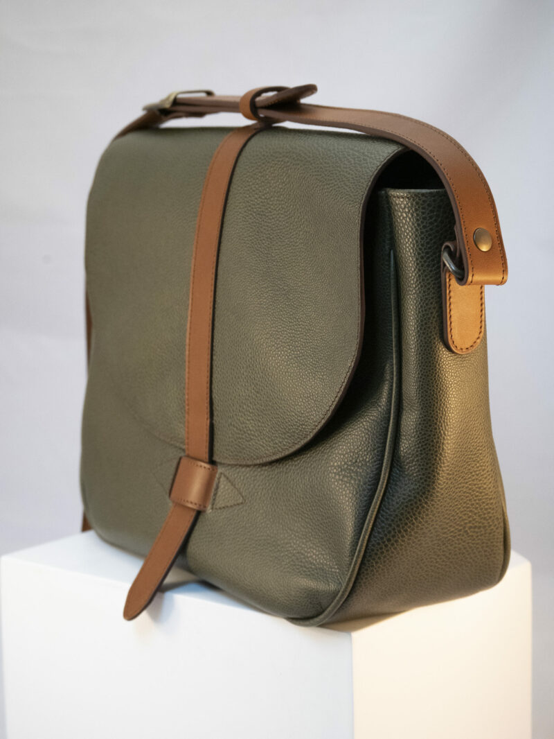 détails du rabat de la besace avec pontet contrasté en cuir camel
