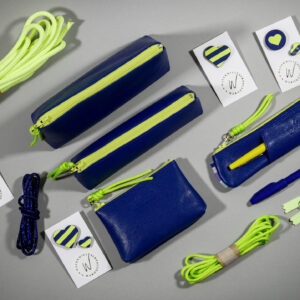 Accessoires Capsule Watermill — famille Berlingot en trois tailles : porte-monnaie XS, trousse S et grande trousse M, en cuir bleu roi avec zip contrasté jaune fluo, pin's cœur bicolores et cordons paracord assortis.