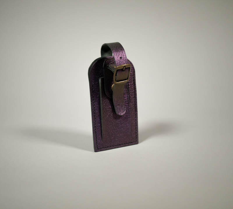 Porte étiquette de bagage en cuir grainé violet bonbon avec fermeture par pression et boucle en laiton vieilli.