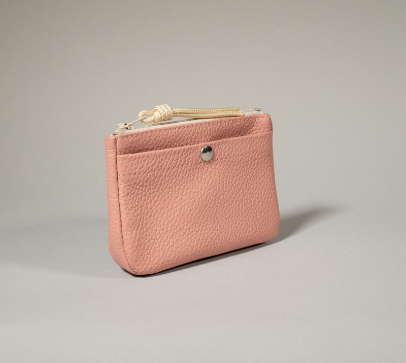 porte monnaie en cuir rose poudré, zippé et compartiment cartes à l'avant fermé par pression métallique, volume donné par un soufflet