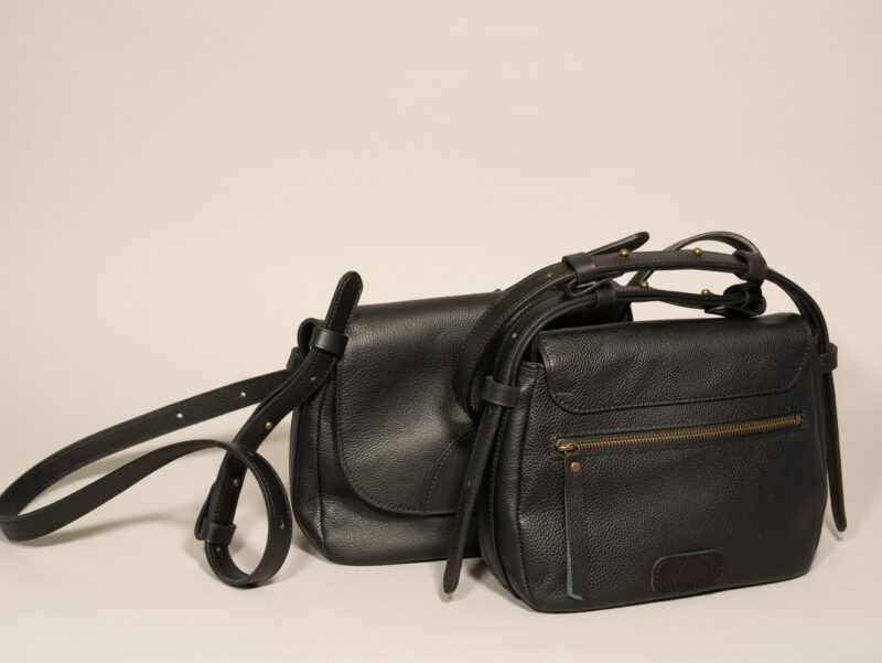 détails de la poche zippée au dos de la besace mini INTEMPORELS, en cuir noir grainé et cuir contrasté noir lisse
