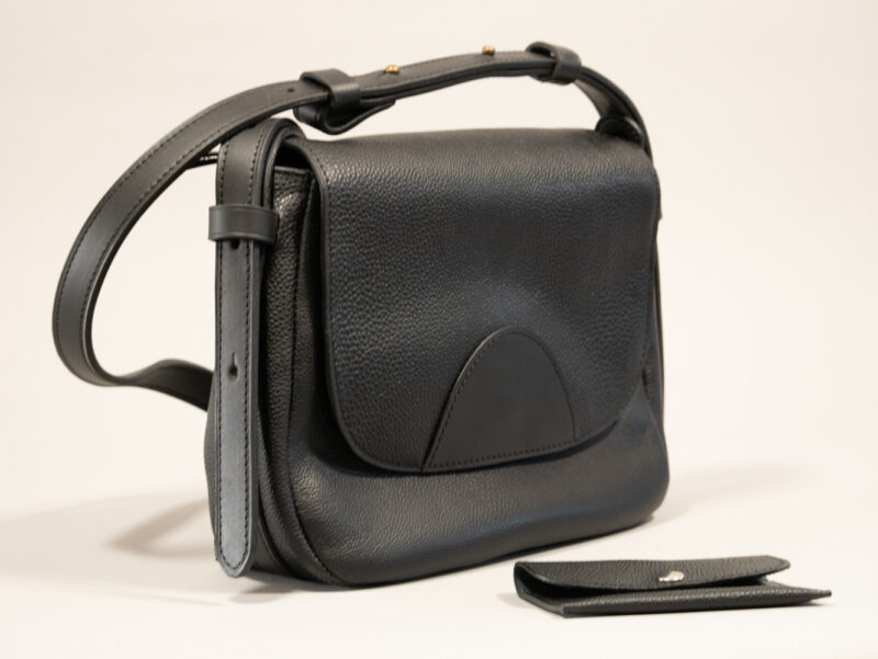 besace mini en cuir grainé noir, fermée par rabat avec sangle réglable en cuir contrasté noir lisse et porte-carte intemporels coordonné