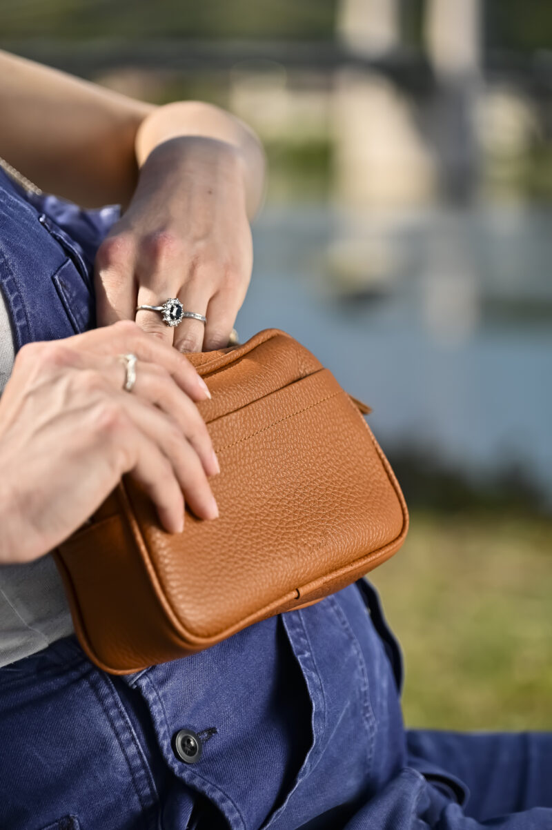 sac camera case en cuir grainé camel, de forme rectangulaire, avec poche avant plaquée porté prêt du corps