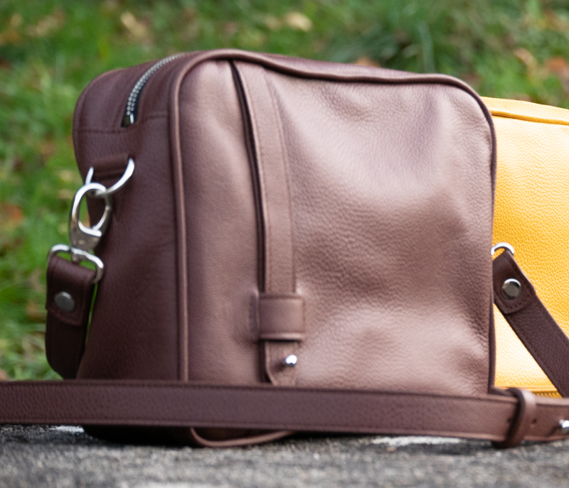 sac reporter collection intemporels en cuir noisette grainé présenté de face en extérieur